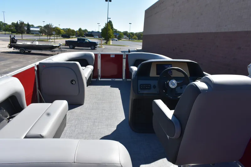 Slide: The Image of 2026 Sun Tracker Party Barge 18 DLX interior with gray seating and steering console. - 7