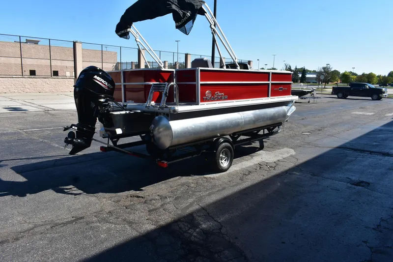 Slide: The Image of 2026 Sun Tracker Party Barge 18 DLX pontoon boat on trailer, parked outdoors. - 82