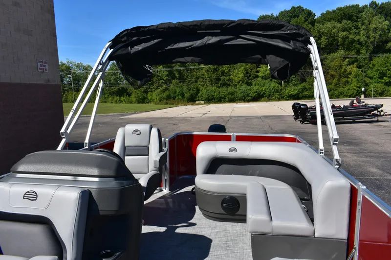 Slide: The Image of 2026 Sun Tracker Party Barge 18 DLX pontoon boat with seating and canopy, parked outdoors. - 88