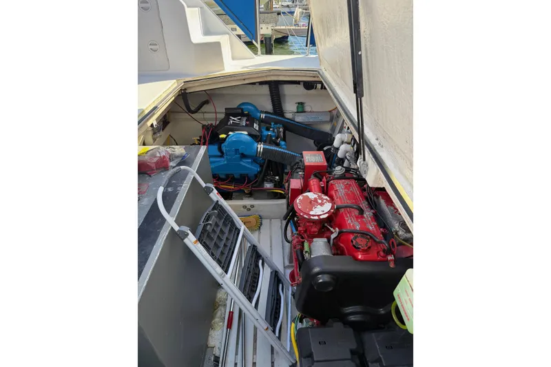 Slide: The Image of Engine compartment of a 1996 Harbor Master 52 Wide Body boat, featuring red and blue engines. - 14