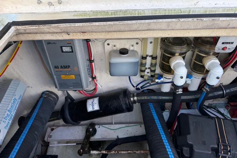 Slide: The Image of Engine compartment of a 1996 Harbor Master 52 Wide Body with battery charger and plumbing. - 17
