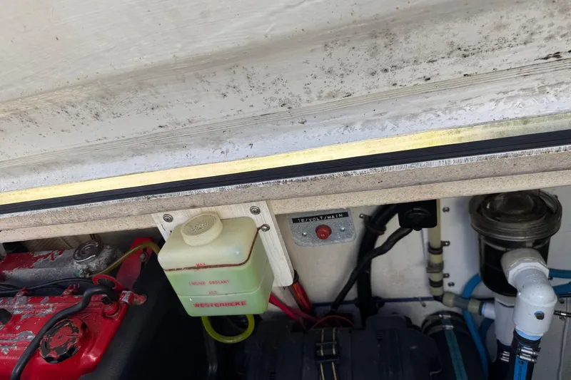 Slide: The Image of Engine compartment of a 1996 Harbor Master 52 Wide Body boat, showing coolant and wiring. - 19