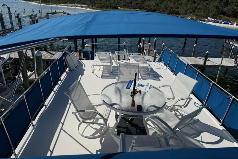 Slide: The Image of 1996 Harbor Master 52 Wide Body yacht deck with blue canopy and seating area. - 2