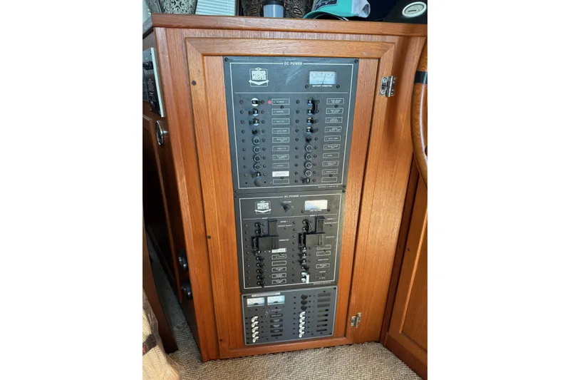 Slide: The Image of Electrical panel on a 1996 Harbor Master 52 Wide Body boat, featuring wooden cabinetry. - 32