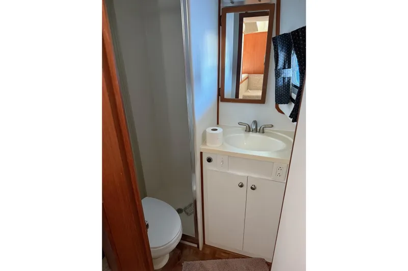 Slide: The Image of Bathroom interior of 1996 Harbor Master 52 Wide Body yacht, featuring sink, mirror, and toilet. - 37