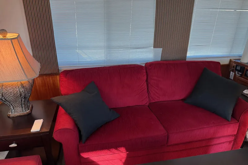 Slide: The Image of Red sofa with black cushions in a 1996 Harbor Master 52 Wide Body yacht interior. - 38