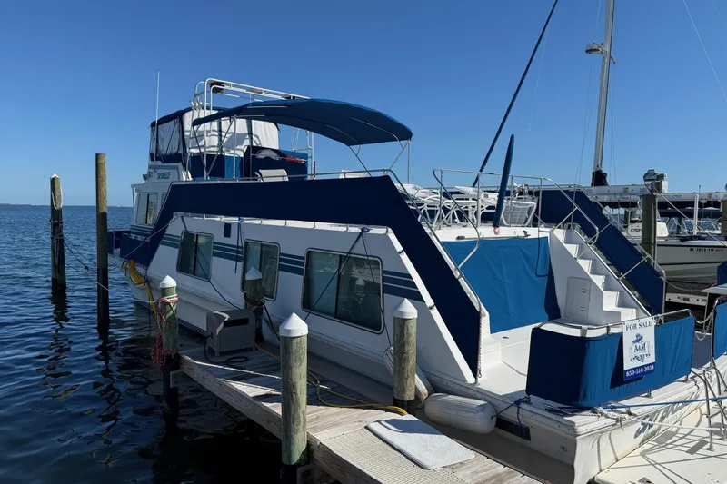 Slide: The Image of 1996 Harbor Master 52 Wide Body houseboat docked, featuring blue and white exterior, for sale. - 7