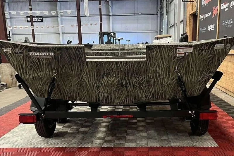 Slide: The Image of 2026 Tracker Grizzly 2072 Utility boat with camo design on a trailer in a showroom. - 7