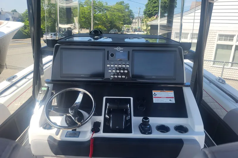 Slide: The Image of 2025 Fountain 34 SC boat dashboard with dual screens and steering wheel. - 13