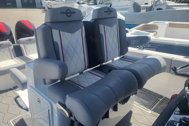 Slide: The Image of 2025 Fountain 34 SC boat seats with luxurious gray and white upholstery, docked in a marina. - 9
