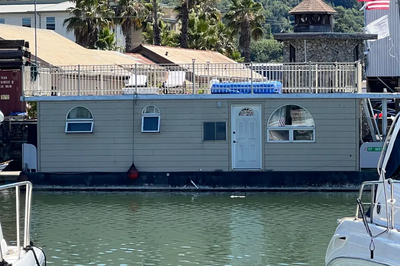 Slide: The Image of Floating home on water with arched windows, rooftop seating, and palm trees in background. - 2