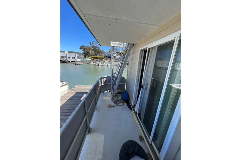 Slide: The Image of Floating home deck with sliding glass doors, overlooking a serene waterfront view. - 9