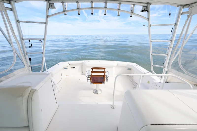Slide: The Image of 1998 Bertram 36 Moppie boat interior with ocean view, featuring fishing chair and equipment. - 12
