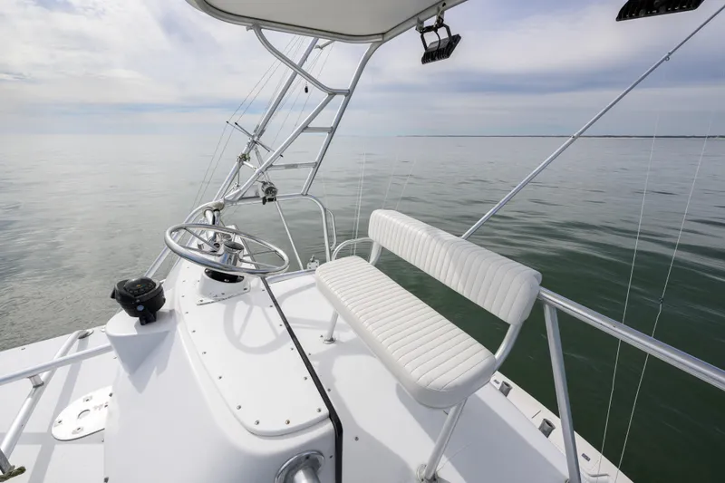 Slide: The Image of 1998 Bertram 36 Moppie boat helm with white seating on calm water. - 18