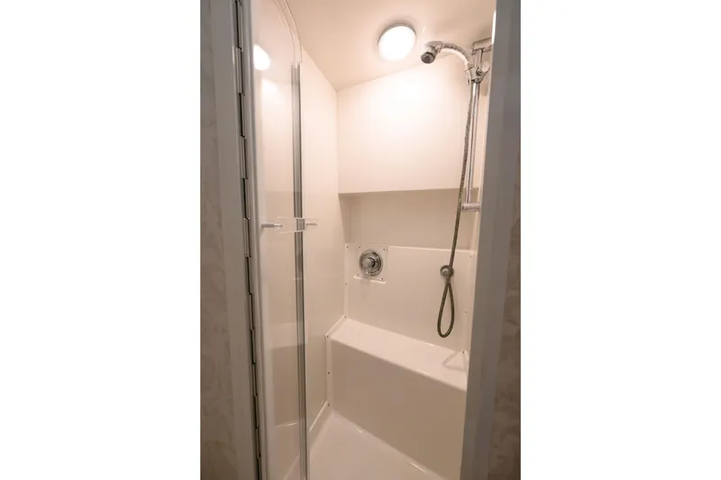 Slide: The Image of Shower area in 1998 Bertram 36 Moppie boat, featuring modern fixtures and lighting. - 24