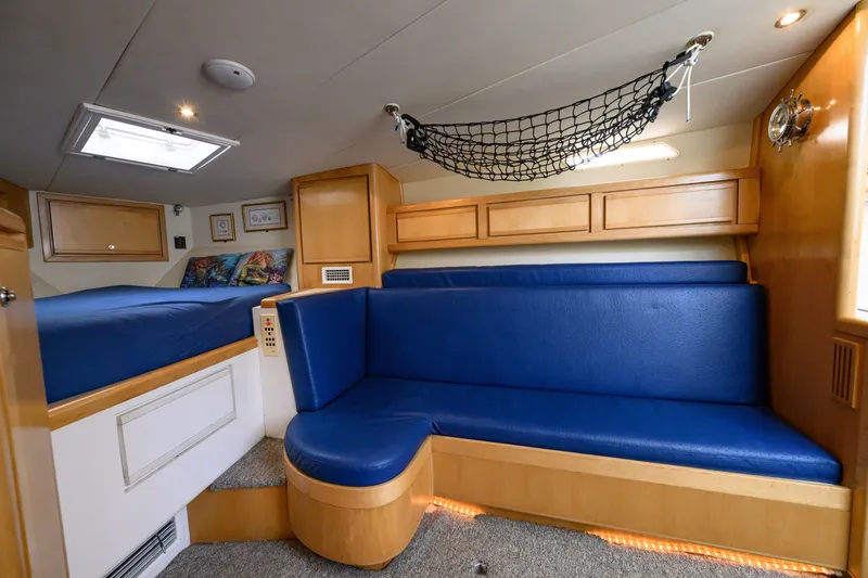 Slide: The Image of Interior of 1998 Bertram 36 Moppie yacht with blue seating and wooden cabinetry. - 30