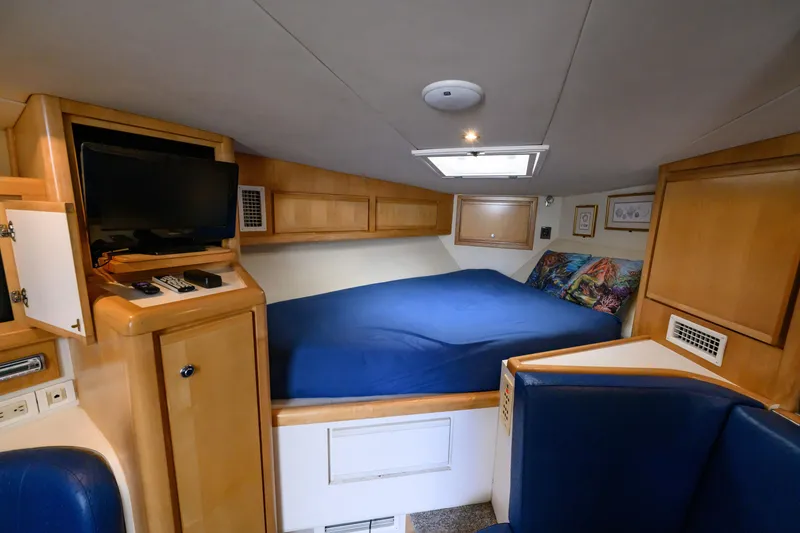 Slide: The Image of Cozy cabin interior of 1998 Bertram 36 Moppie with bed, TV, and wooden cabinetry. - 33