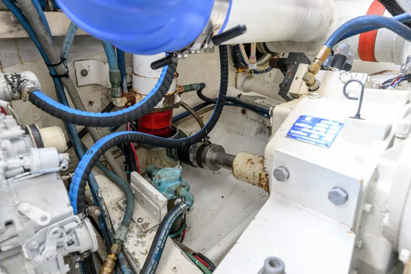 Slide: The Image of Engine room of a 1998 Bertram 36 Moppie, featuring hoses and mechanical components. - 36