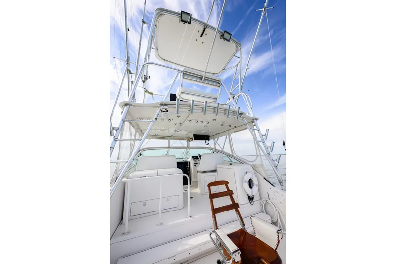 Slide: The Image of 1998 Bertram 36 Moppie yacht interior with seating, ladder, and clear sky background. - 6