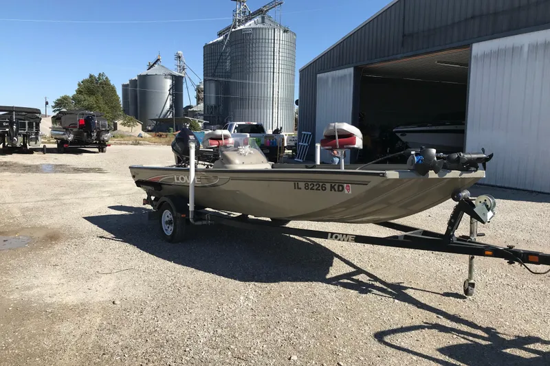 Slide: The Image of 2007 Lowe Stinger 170 boat on trailer near industrial silos and warehouse. - 11