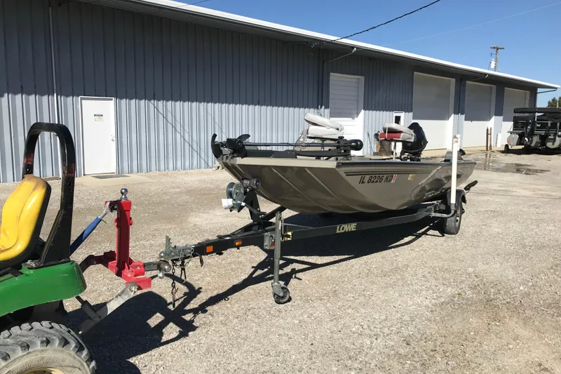 Slide: The Image of 2007 Lowe Stinger 170 boat on trailer, parked outside a metal building. - 12