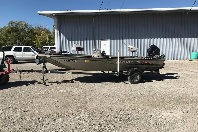 Slide: The Image of 2007 Lowe Stinger 170 boat on trailer, parked outside a metal building. - 13