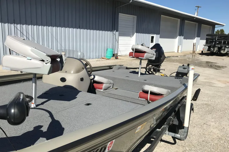 Slide: The Image of 2007 Lowe Stinger 170 boat with fishing seats, parked near a metal building. - 18