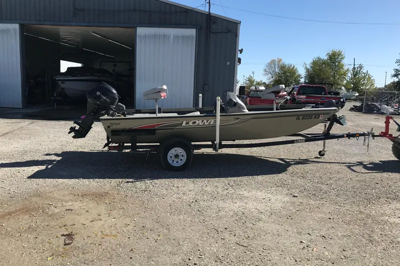 Slide: The Image of 2007 Lowe Stinger 170 boat on trailer outside a garage. - 7
