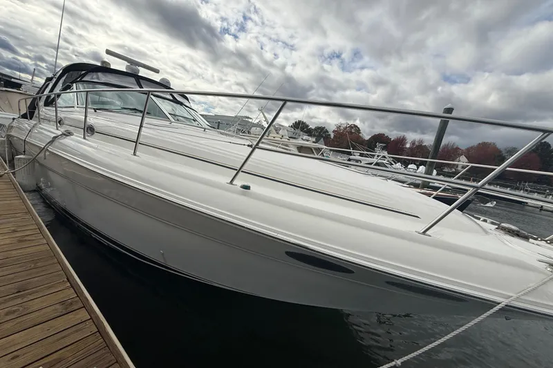 The Image of 2001 Sea Ray 410 Sundancer yacht docked under cloudy skies. - 1