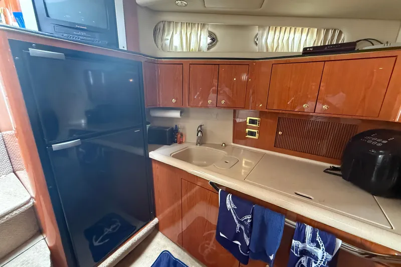 Slide: The Image of Interior of 2001 Sea Ray 410 Sundancer yacht kitchen with wood cabinets and appliances. - 10
