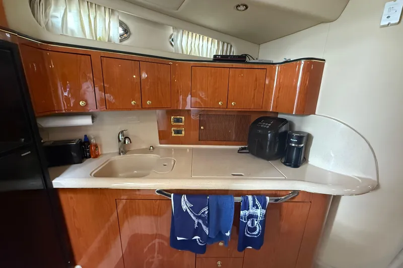 Slide: The Image of 2001 Sea Ray 410 Sundancer kitchen with wooden cabinets, sink, and appliances. - 11