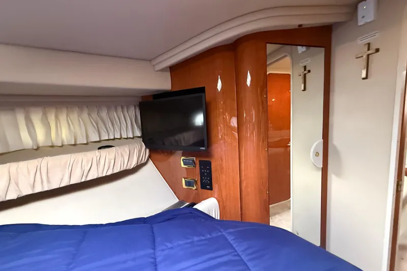 Slide: The Image of Interior of 2001 Sea Ray 410 Sundancer with TV, bed, and wooden paneling. - 14