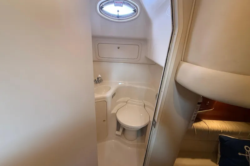 Slide: The Image of Bathroom interior of 2001 Sea Ray 410 Sundancer yacht, featuring compact design and porthole window. - 16