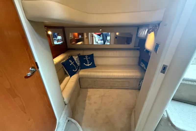 Slide: The Image of Interior of 2001 Sea Ray 410 Sundancer with beige seating and nautical-themed pillows. - 17