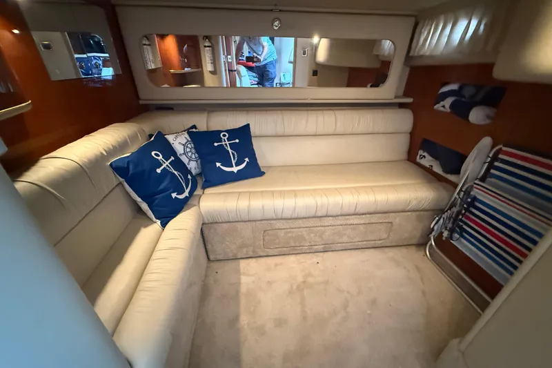 Slide: The Image of Interior of 2001 Sea Ray 410 Sundancer with beige seating and nautical-themed pillows. - 18