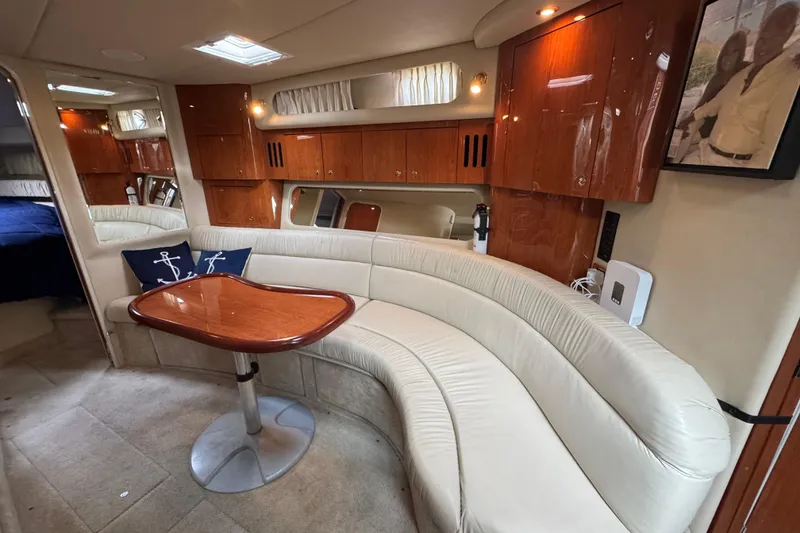 Slide: The Image of Luxurious interior of 2001 Sea Ray 410 Sundancer yacht with curved seating and wooden table. - 8