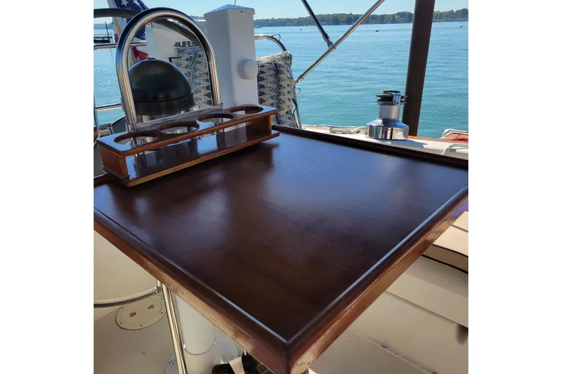 Slide: The Image of Wooden cockpit table on 1984 Pearson 386 sailboat, overlooking serene water. - 23
