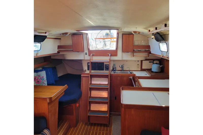 Slide: The Image of Interior of 1984 Pearson 386 sailboat with cozy seating and compact kitchen area. - 29