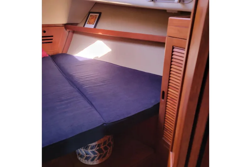 Slide: The Image of Cozy cabin interior of 1984 Pearson 386 sailboat with blue bedding and wooden accents. - 34