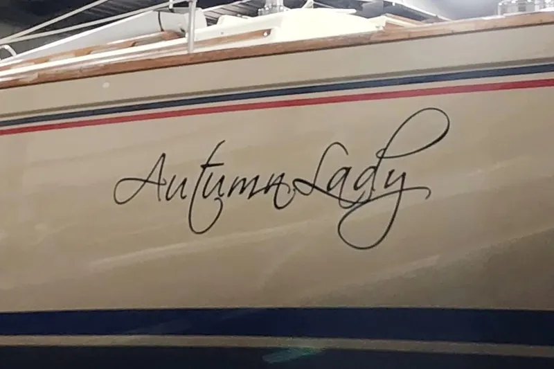 Slide: The Image of 1984 Pearson 386 sailboat named "Autumn Lady" with elegant script on the hull. - 44