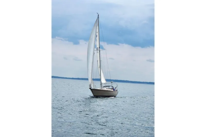 Slide: The Image of Sailboat Pearson 386, 1984 model, cruising on calm waters under a cloudy sky. - 1