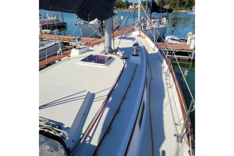 Slide: The Image of 1984 Pearson 386 sailboat deck view at marina, showcasing rigging and hatch. - 13