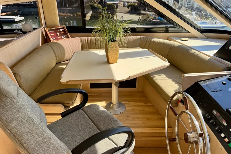 Slide: The Image of 1993 Tollycraft 57 Pilothouse Motor Yacht deck with wooden chairs and table. - 13