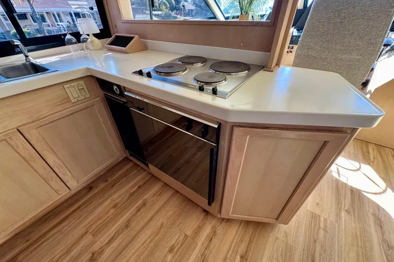 Slide: The Image of 1993 Tollycraft 57 Pilothouse Motor Yacht kitchen with modern appliances and wood cabinetry. - 16