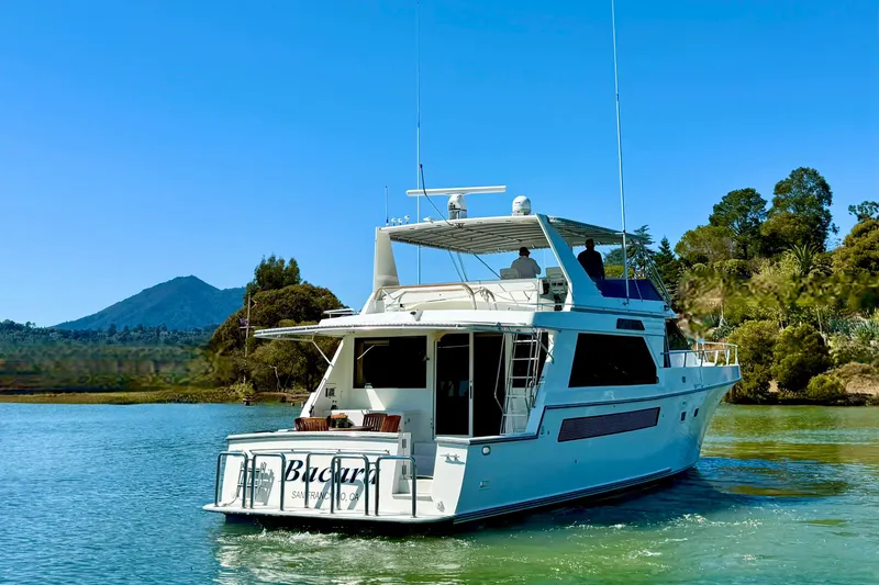 Slide: The Image of 1993 Tollycraft 57 Pilothouse Motor Yacht cruising on a serene waterway. - 4