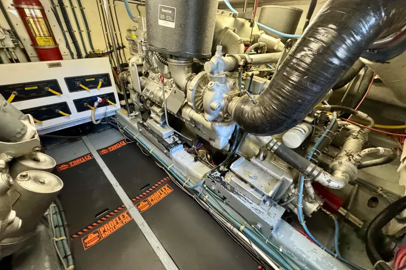 Slide: The Image of Engine room of 1993 Tollycraft 57 Pilothouse Motor Yacht, featuring complex machinery and control panels. - 45