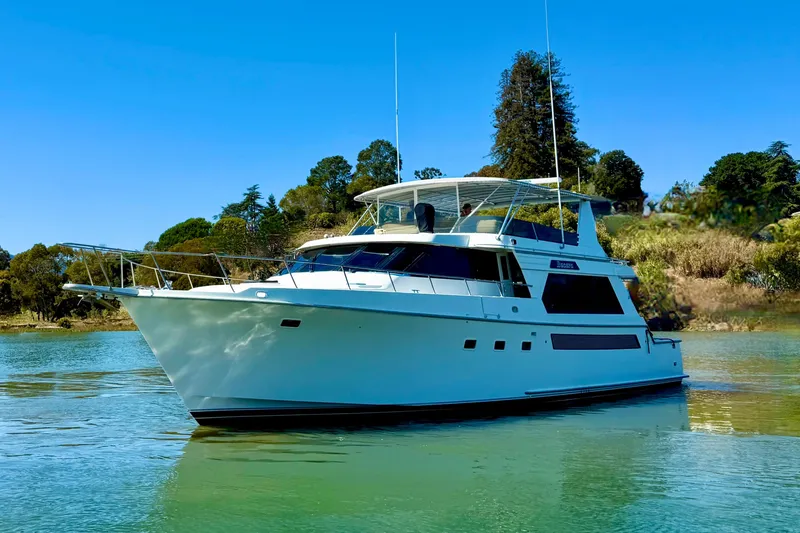 Slide: The Image of 1993 Tollycraft 57 Pilothouse Motor Yacht cruising on a scenic lake with mountain backdrop. - 5
