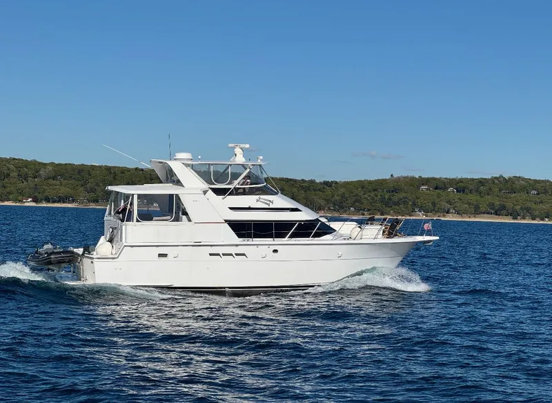 The Image of 1994 Hatteras 48 Cockpit MY yacht cruising on blue water under clear sky. - 0