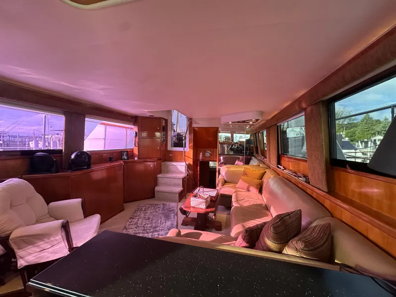 Slide: The Image of Luxurious interior of 1994 Hatteras 48 Cockpit MY yacht with plush seating and wood finishes. - 16