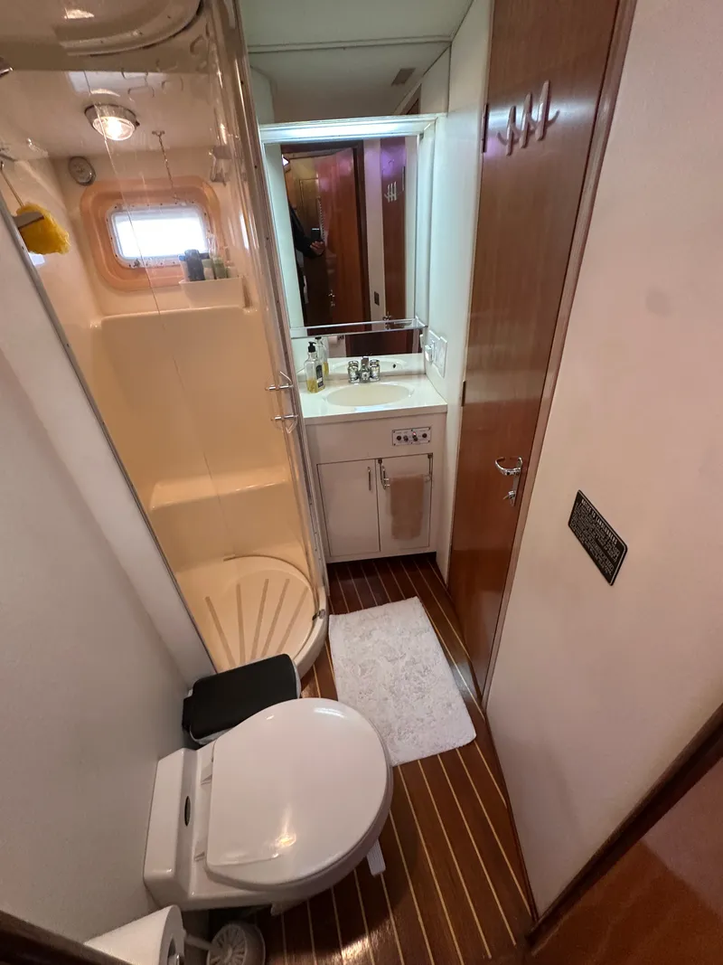 Slide: The Image of Bathroom interior of 1994 Hatteras 48 Cockpit MY yacht, featuring shower, toilet, and sink. - 21